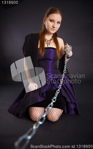 Image of Young beautiful girl pulls out a chain leash