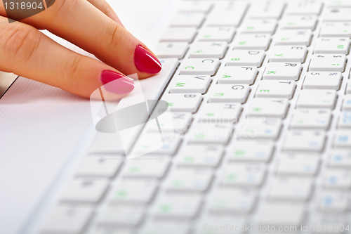 Image of Female fingers on white laptop keyboard