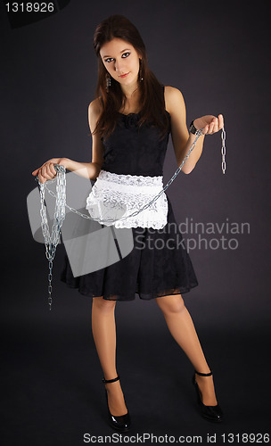 Image of Young servant girl in black dress holding a chain