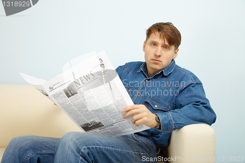 Image of Man disappointed with news from newspaper