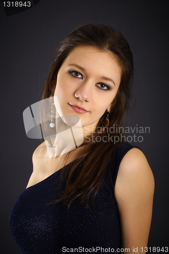 Image of Portrait of a beautiful young woman in evening dress on black ba