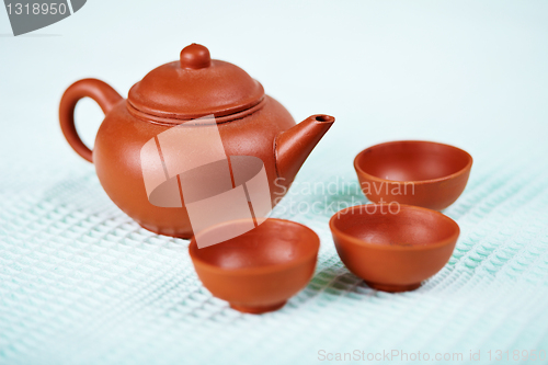 Image of Ceramic teapot and cups on blue towel
