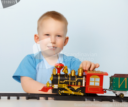 Image of Little boy playing with a toy locomotive