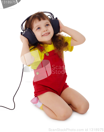 Image of Little girl listens to music