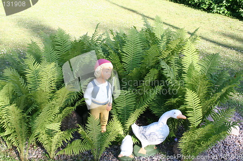 Image of Geese and boy standing among ferns