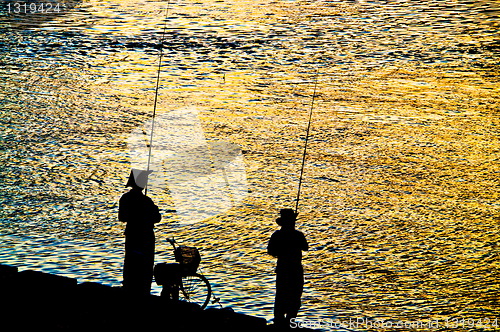 Image of Fisherman silhouette  on shoreline