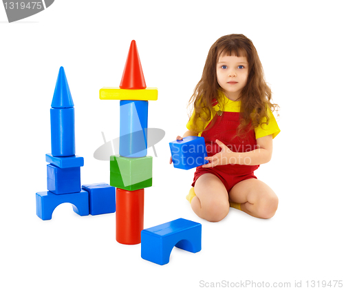 Image of Child builds a toy castle on floor