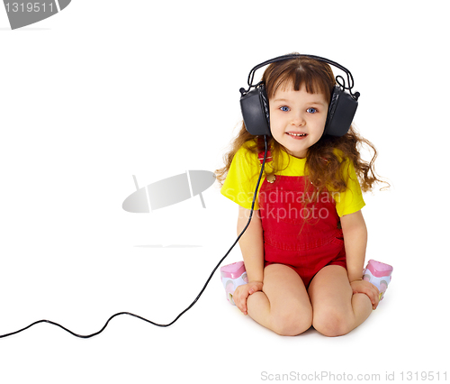 Image of Child listens attentively to music on white