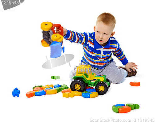 Image of Little boy playing actively with plastic toys