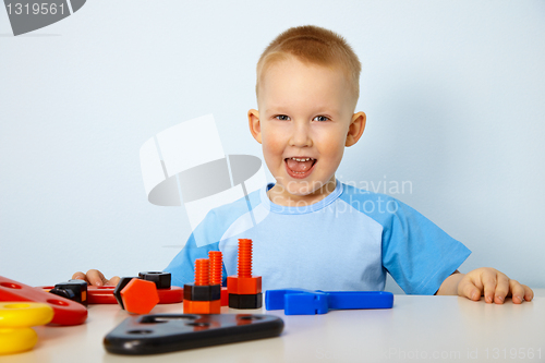 Image of Happy little boy playing with toys