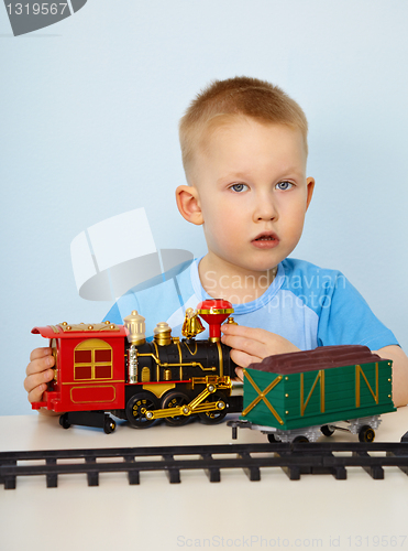 Image of Little boy playing with a toy locomotive