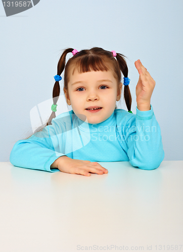 Image of Little girl sitting at school desk