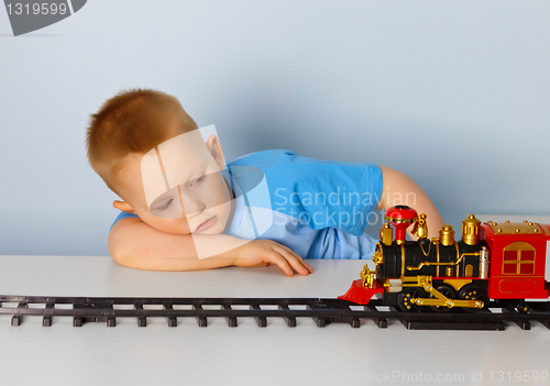 Image of Little boy playing with a toy locomotive