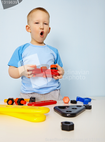 Image of Little kid playing with plastic toys