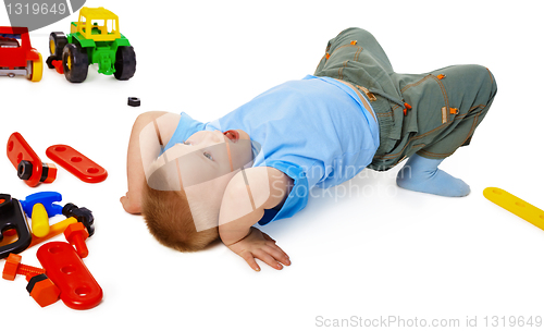 Image of Child fooling on the floor among the toys