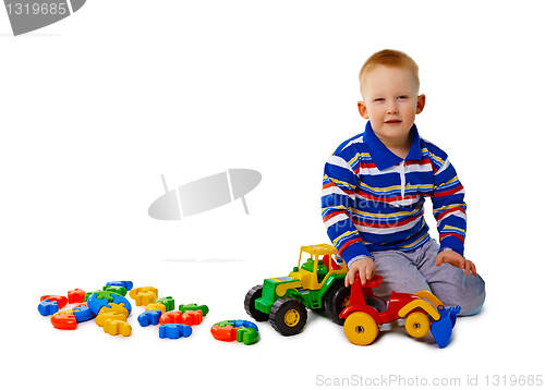 Image of Boy sits on white background with toys