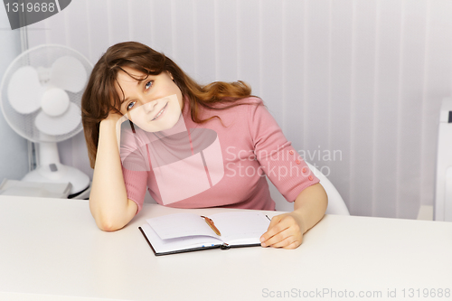 Image of Beautiful woman sitting at table