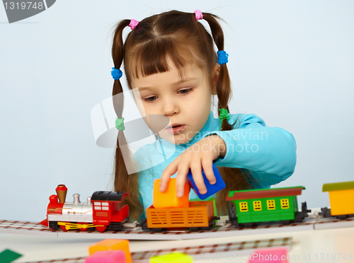 Image of Little girl preschooler playing with toy railway