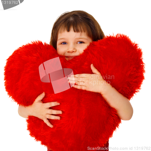 Image of Little girl hugging a large toy heart