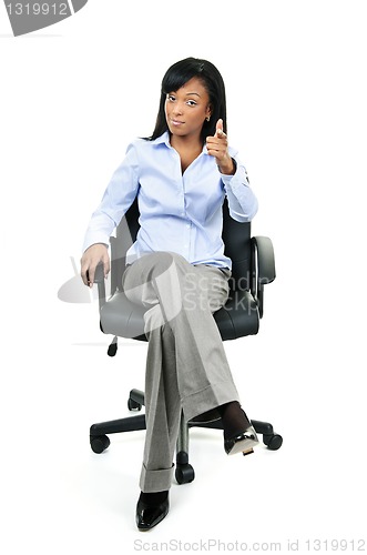 Image of Businesswoman pointing sitting on office chair