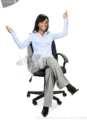 Image of Happy businesswoman sitting on office chair