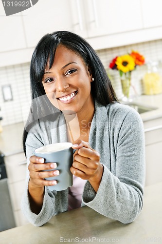 Image of Woman in kitchen with coffee cup