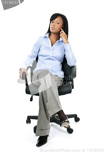 Image of Businesswoman on phone sitting in office chair