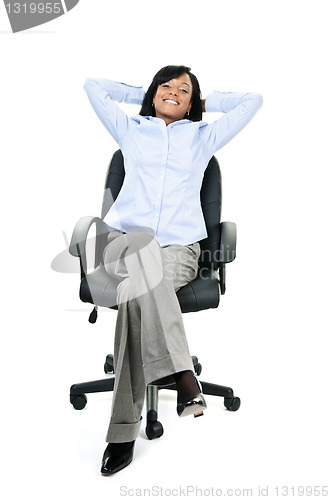 Image of Relaxed businesswoman sitting on office chair