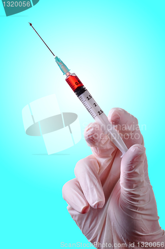 Image of Hand holding a syringe