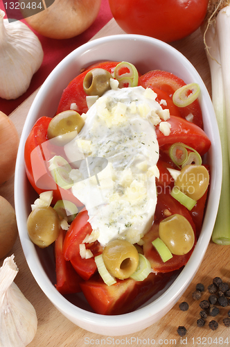 Image of Tomato salad with herb yoghurt and olives in a bowl