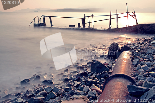 Image of old metal pipe and road to sea