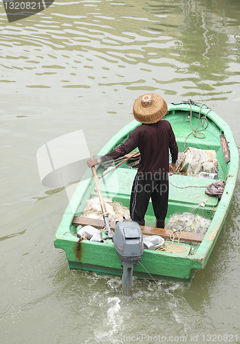 Image of man on sampan boat with outboard motor 