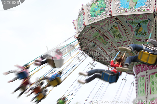 Image of child plaaying flying swing in park