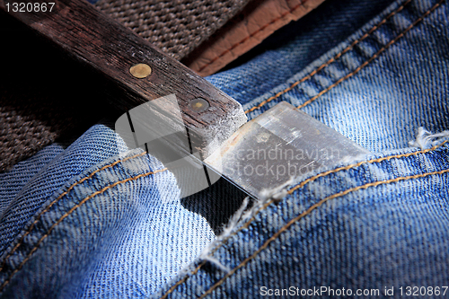 Image of knife in jeans pocket 