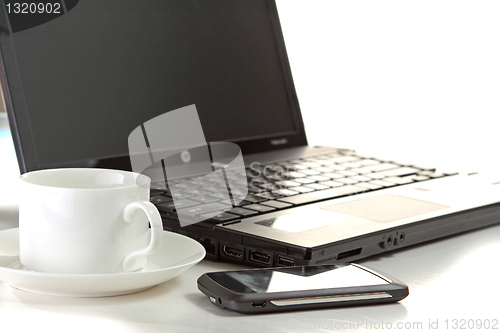 Image of A cup of coffee and a pen on a laptop 