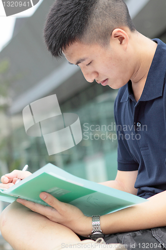 Image of casual asian businessman texting on his book. 