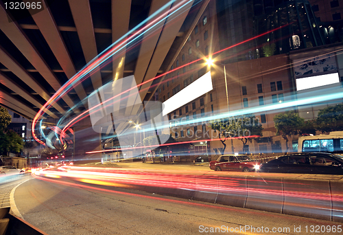 Image of blurred bus light trails in downtown night-scape 