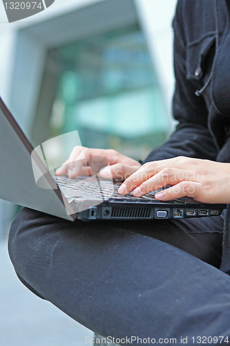 Image of loseup of a young man working of a laptop 