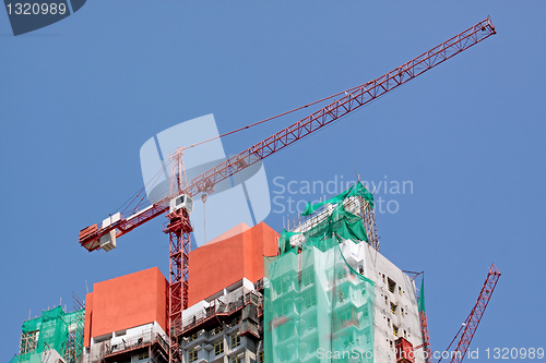 Image of Construction crane at the construction site, on a cloudless sky 