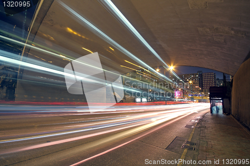 Image of blurred bus light trails in downtown night-scape 