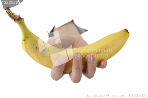 Image of  hand from a hole is holding a banana