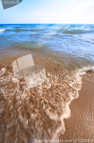 Image of Beach pebbles under clear water with waves