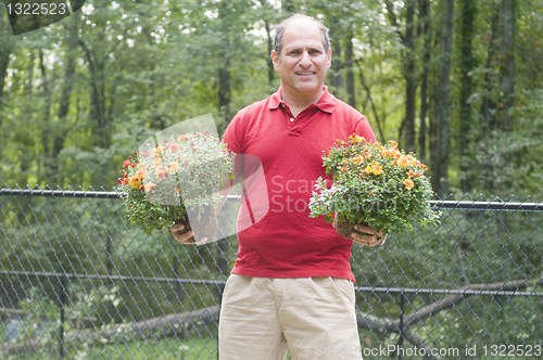 Image of male homeowner gardening flowers outdoors