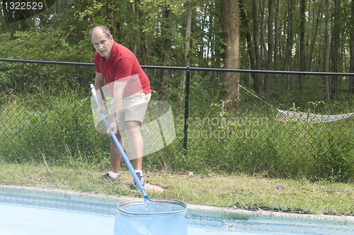 Image of homeowner cleaning swimming pool