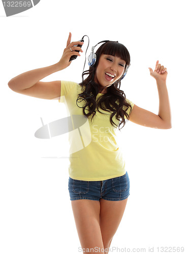 Image of Vivacious girl listening to music and dancing