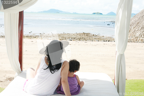 Image of mom with a child watching the beach on the bed