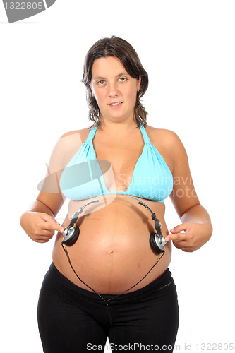 Image of beautiful pregnant woman with headphones in belly