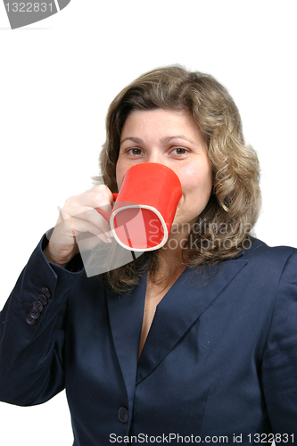 Image of beautiful woman drinking a red mug of coffee