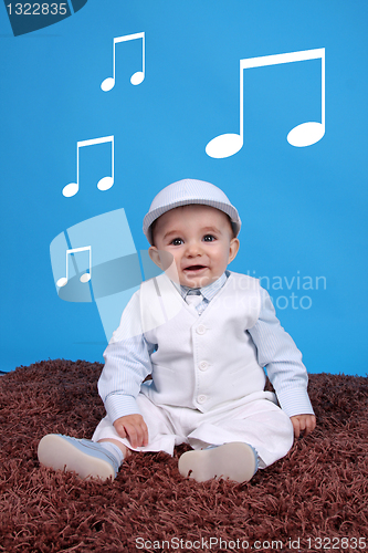 Image of Portrait of a happy baby boy Isolated on blue background listen 