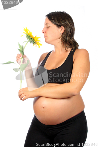 Image of pregnant woman with beautiful belly and sunflower